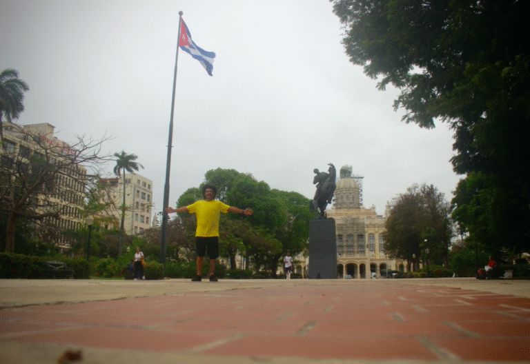Tiago Prado em Cuba, com a bandeira cubana, em resposta ao "vai pra cuba eu fui" dos críticos.