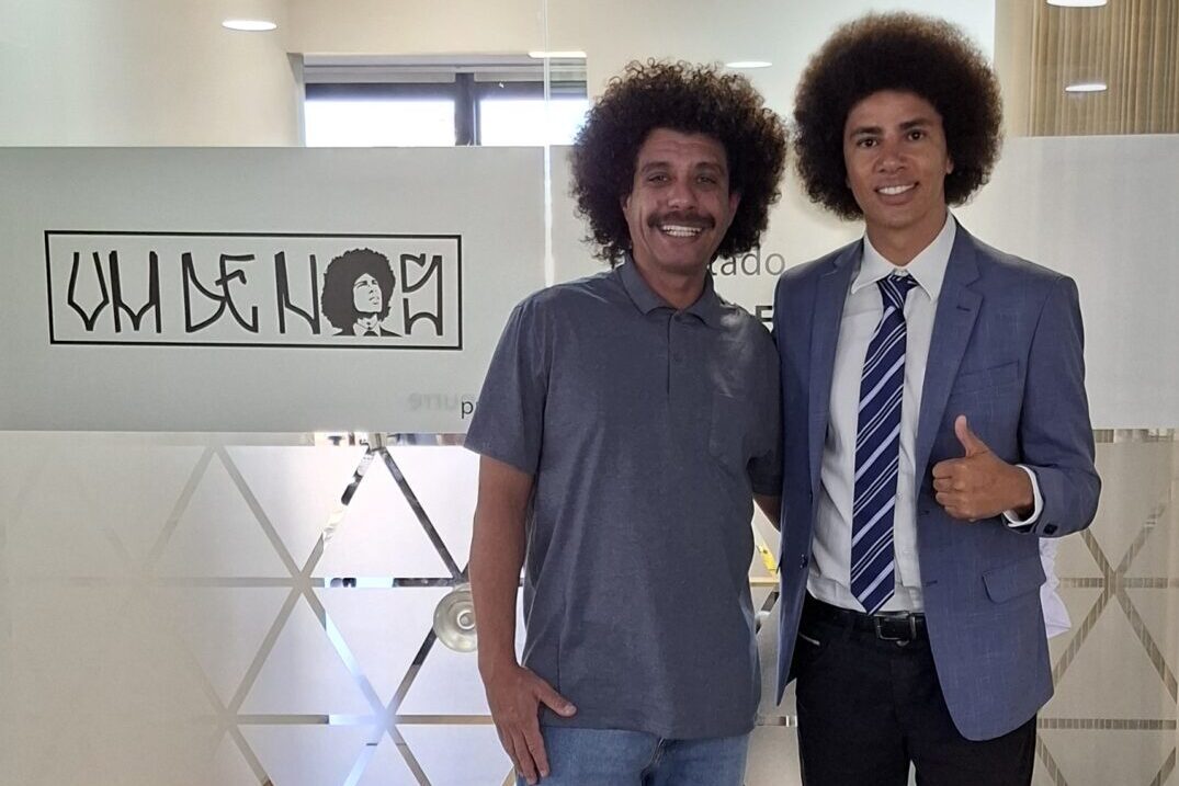 Dois homens, Tiago Prado e Renato Freitas, com cabelos crespos posam sorrindo em apoio à luta contra o racismo e à resistência democrática
